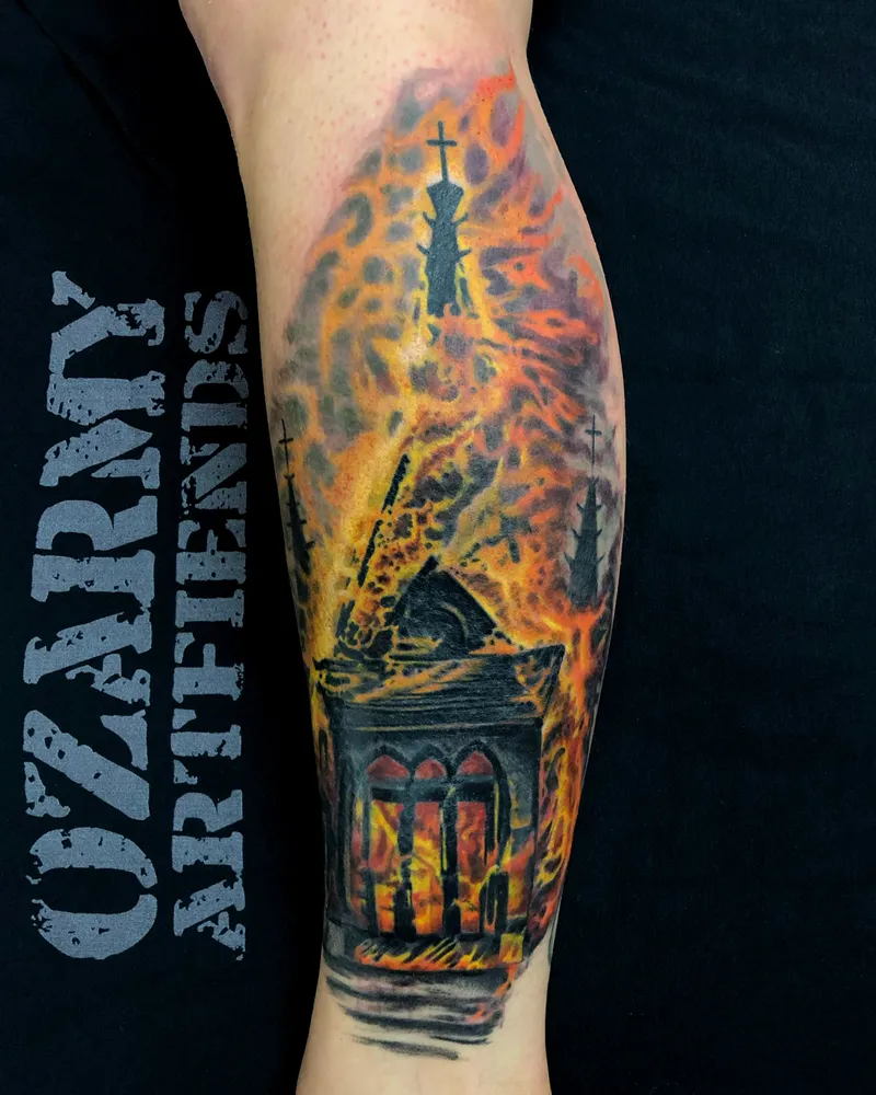 Color tattoo of a burning gothic church with crosses and steeples engulfed in flames on the calf