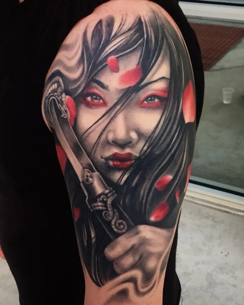 Color tattoo of a fierce geisha-warrior with red eye makeup and cherry blossom petals, gripping a sword