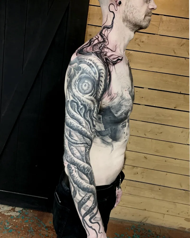 Full arm bioorganic freehand tattoo with a large eye on the shoulder, side profile